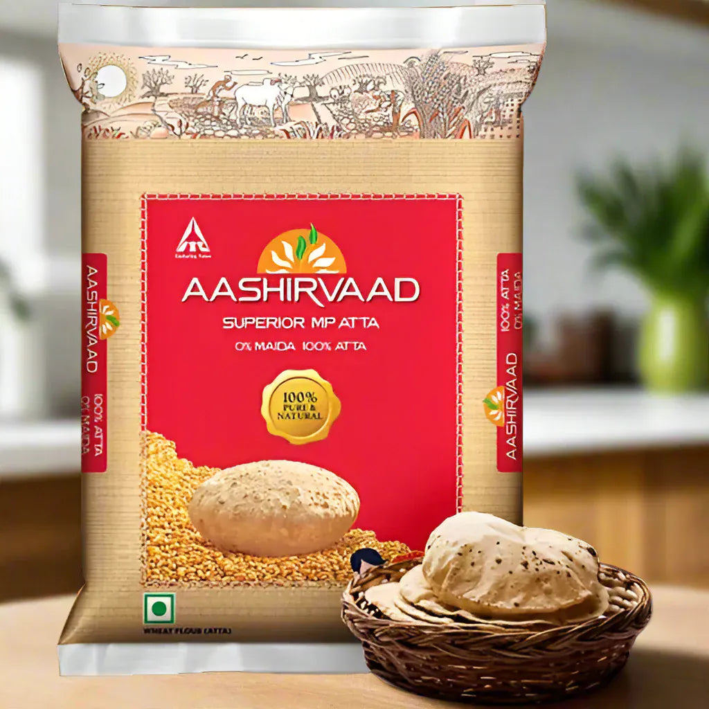 Aashirvaad Atta flour bags with a decorative design, prominently displaying the brand and product name, against a kitchen backdrop.